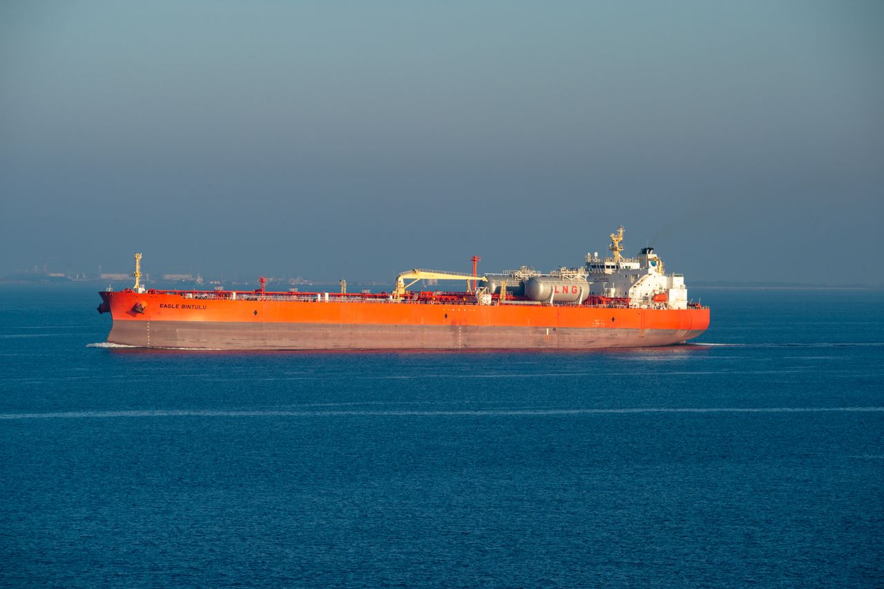 Crafting Captivating Headlines: Your awesome post title goes here Bright orange LNG carrier ship cruising through calm sea waters on a clear day.